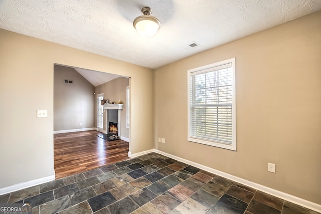 empty room featuring a textured ceiling and dark wood-type flooring