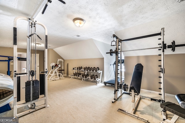 workout area with a textured ceiling, vaulted ceiling, and carpet flooring