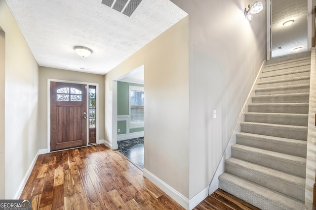 foyer with a textured ceiling and hardwood / wood-style flooring