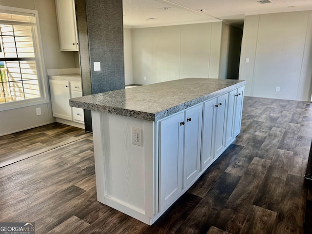 kitchen featuring dark wood-type flooring, white cabinetry, and a center island