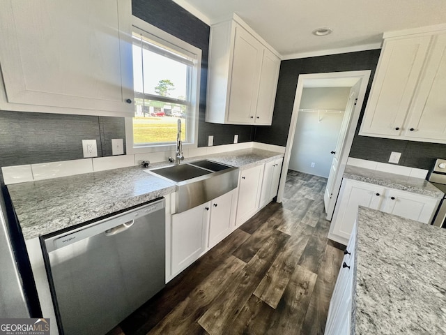 kitchen featuring white cabinetry, dark hardwood / wood-style flooring, sink, stainless steel dishwasher, and decorative backsplash