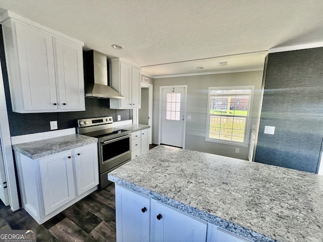 kitchen with electric stove, white cabinetry, light stone countertops, and wall chimney range hood