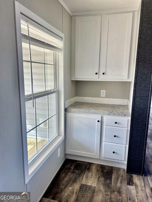 interior space featuring white cabinetry, light stone countertops, and dark hardwood / wood-style flooring