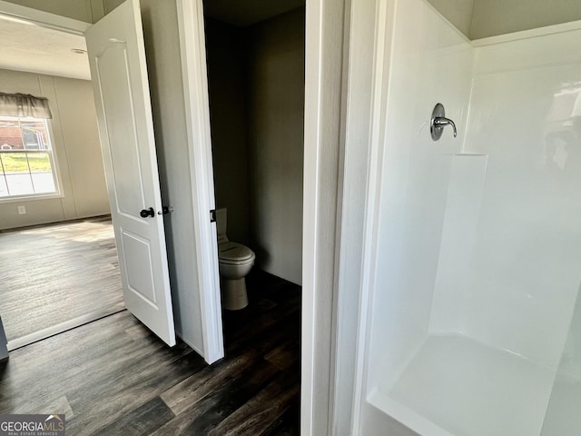 bathroom with wood-type flooring, toilet, and walk in shower