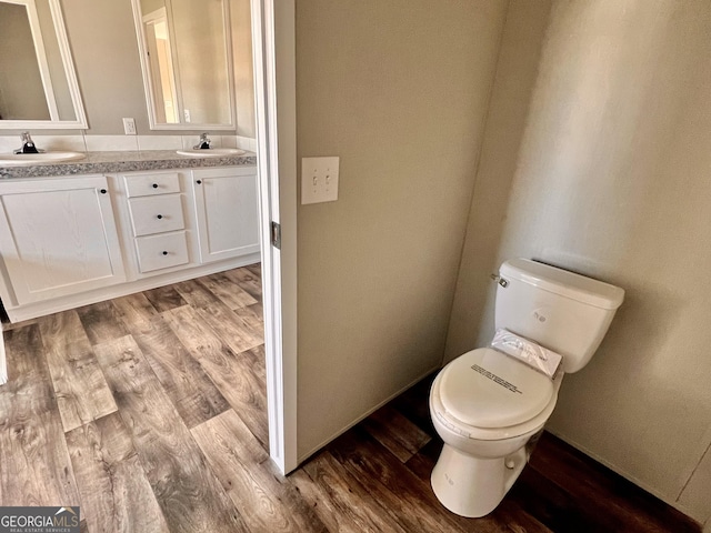 bathroom featuring toilet, vanity, and hardwood / wood-style floors