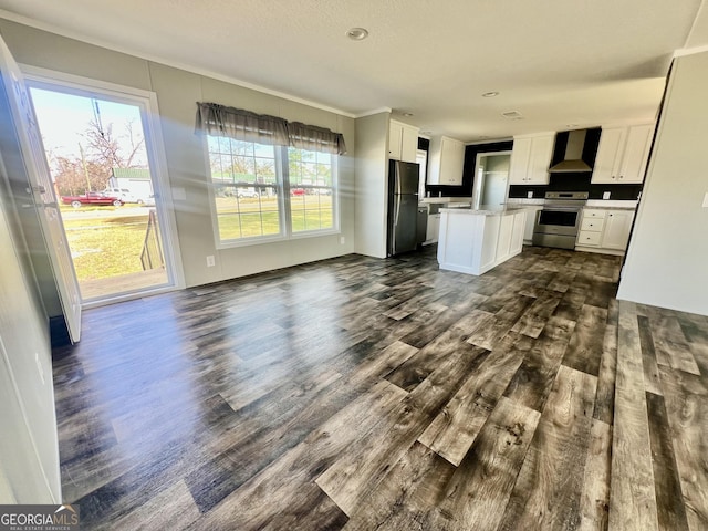 kitchen with white cabinets, wall chimney exhaust hood, black refrigerator, and electric range