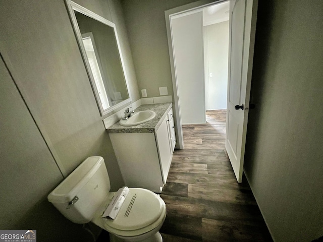 bathroom with hardwood / wood-style flooring, vanity, and toilet