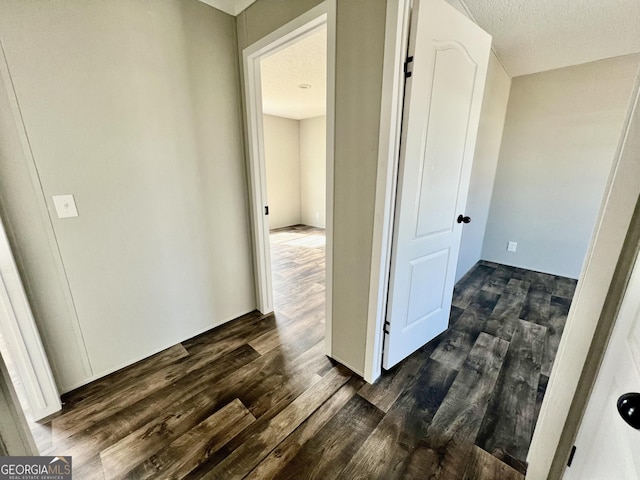 corridor featuring dark hardwood / wood-style floors and a textured ceiling