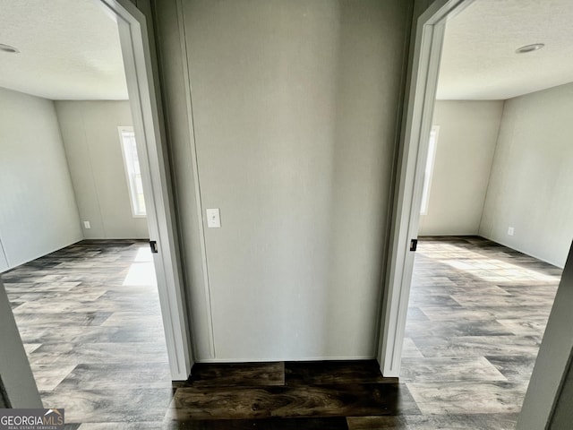 hall with a textured ceiling and hardwood / wood-style flooring