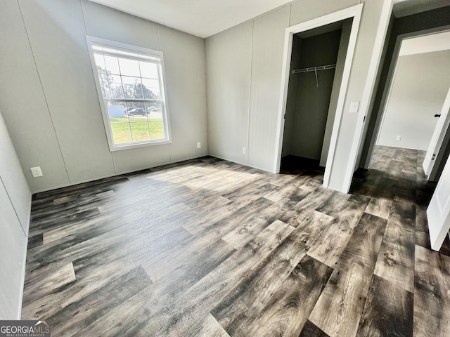 unfurnished bedroom featuring dark hardwood / wood-style floors and a closet