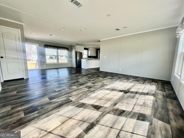 unfurnished living room with ornamental molding and wood-type flooring