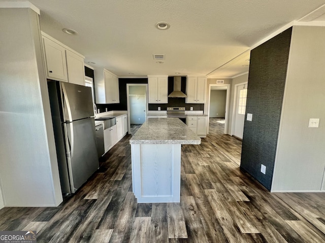 kitchen with white cabinetry, wall chimney range hood, stainless steel appliances, and dark hardwood / wood-style flooring