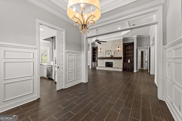 interior space featuring ceiling fan with notable chandelier, dark wood-type flooring, a fireplace, built in features, and ornamental molding