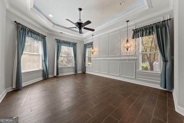 spare room featuring ornamental molding, dark hardwood / wood-style floors, ceiling fan, and a raised ceiling