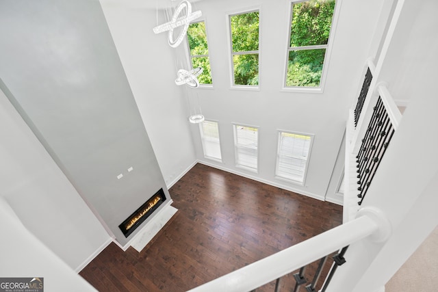 868 Still Hill Ln, Lawrenceville, GA 30045 - foyer entrance featuring stairway, a towering ceiling, wood finished floors, a warm lit fireplace, and a chandelier