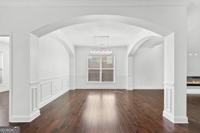 868 Still Hill Ln, Lawrenceville, GA 30045 - interior space featuring dark wood-style flooring, a glass covered fireplace, ornamental molding, and a wainscoted wall