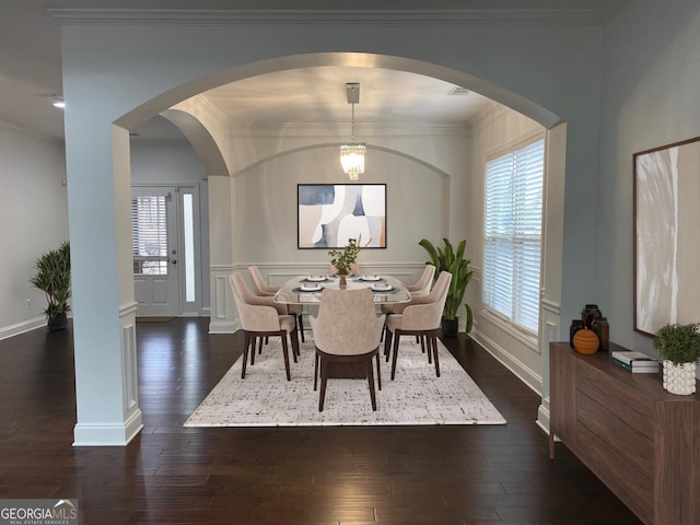 868 Still Hill Ln, Lawrenceville, GA 30045 - dining room featuring dark wood-style floors, ornamental molding, and arched walkways