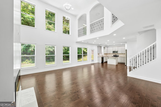 868 Still Hill Ln, Lawrenceville, GA 30045 - unfurnished living room featuring a high ceiling, plenty of natural light, dark wood-style floors, stairway, and recessed lighting