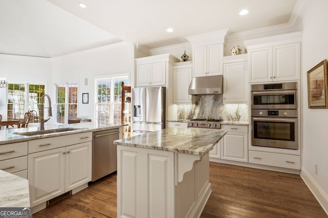 kitchen with appliances with stainless steel finishes, sink, a kitchen island with sink, and white cabinets