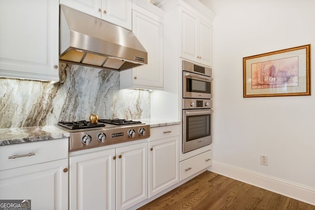 kitchen featuring white cabinetry, tasteful backsplash, light stone countertops, and stainless steel appliances