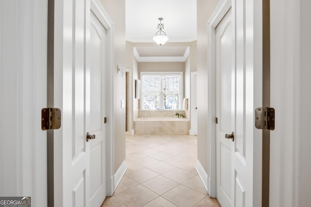 corridor with light tile patterned floors and crown molding