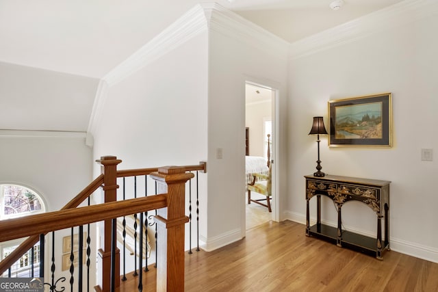 hallway with light hardwood / wood-style flooring and ornamental molding