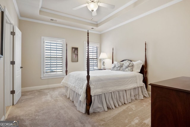 bedroom featuring a tray ceiling, ceiling fan, crown molding, and light colored carpet