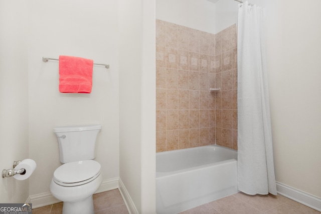 bathroom featuring tile patterned floors, toilet, and shower / tub combo with curtain