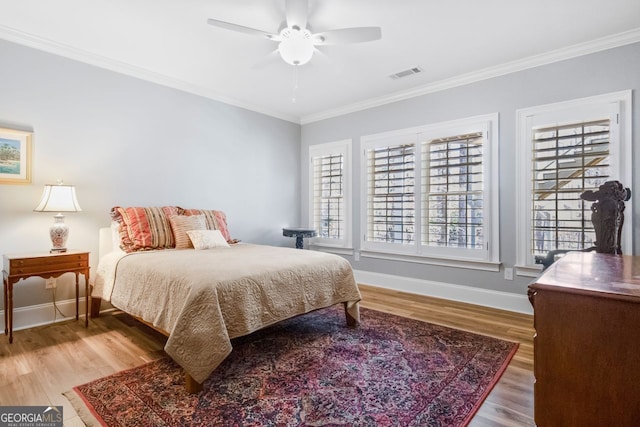 bedroom with hardwood / wood-style flooring, ceiling fan, and ornamental molding