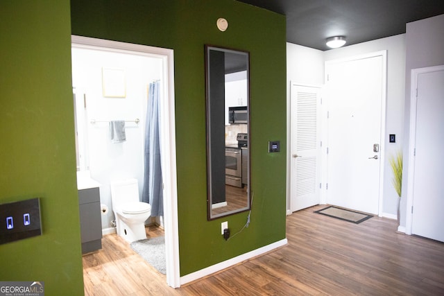 foyer featuring baseboards and wood finished floors