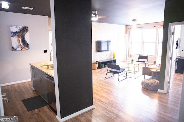 interior space with a sink, baseboards, visible vents, and wood finished floors