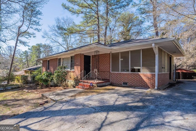 ranch-style house with brick siding and aphalt driveway