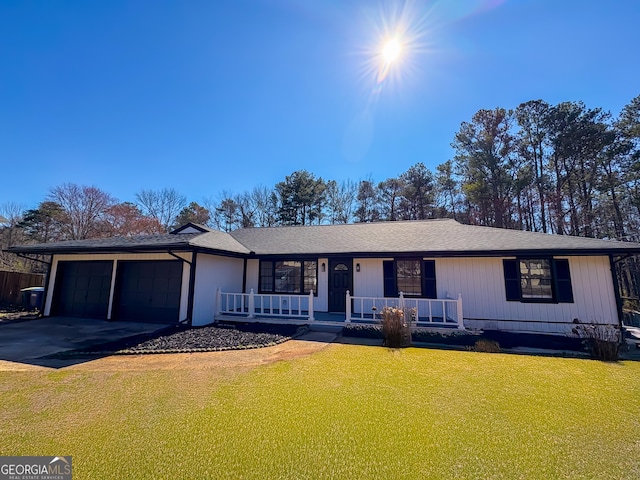 ranch-style house with covered porch, aphalt driveway, an attached garage, and a front yard