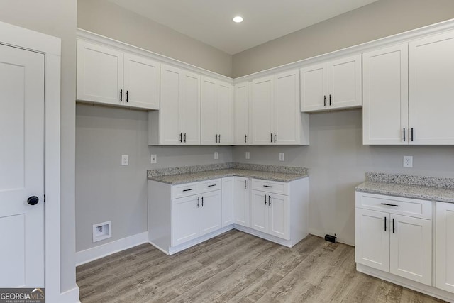 kitchen with light wood-style floors, recessed lighting, white cabinets, and light stone countertops