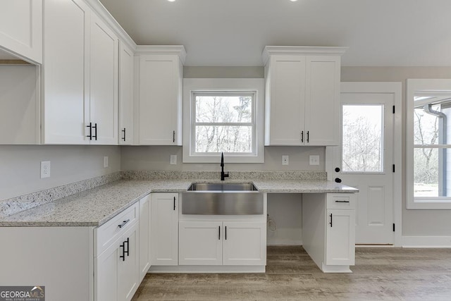 kitchen with a wealth of natural light, white cabinetry, and a sink