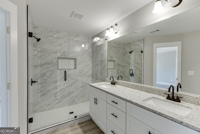 bathroom with visible vents, a sink, and double vanity