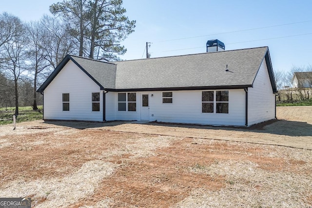 rear view of property with a shingled roof