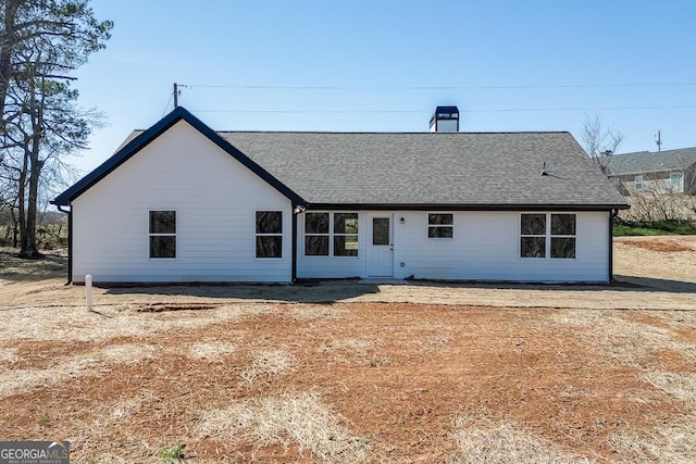 view of front of house with a shingled roof and a chimney