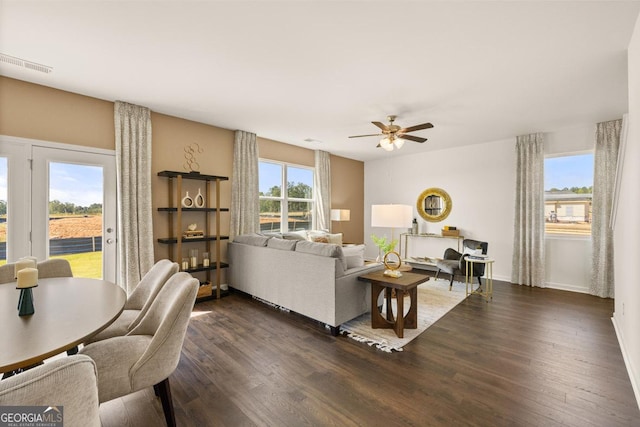 living room featuring ceiling fan, a wealth of natural light, and dark hardwood / wood-style flooring