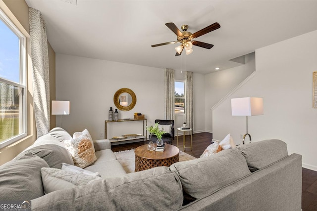 living room featuring dark wood-type flooring and ceiling fan