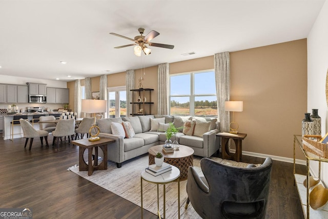 living room with dark wood-type flooring and ceiling fan