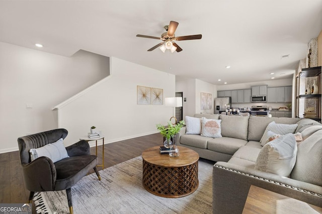 living room featuring ceiling fan and dark wood-type flooring