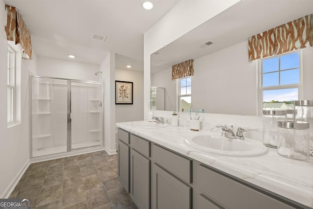 bathroom with vanity and a shower with door