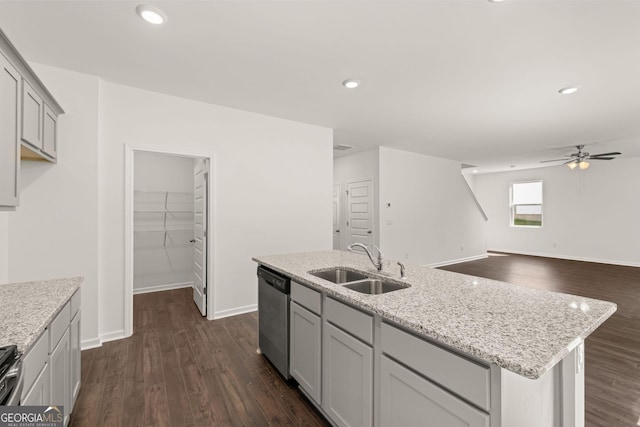 kitchen with sink, a center island with sink, stainless steel dishwasher, and light stone countertops