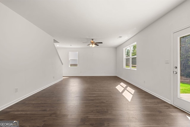 unfurnished living room with dark hardwood / wood-style flooring and ceiling fan