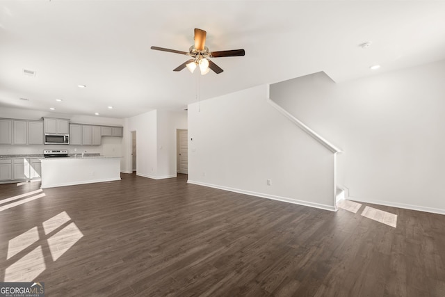 unfurnished living room with dark hardwood / wood-style floors and ceiling fan