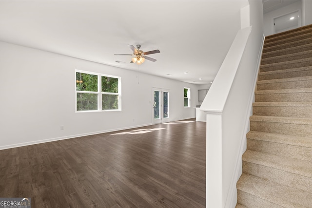 unfurnished living room featuring ceiling fan and dark hardwood / wood-style flooring