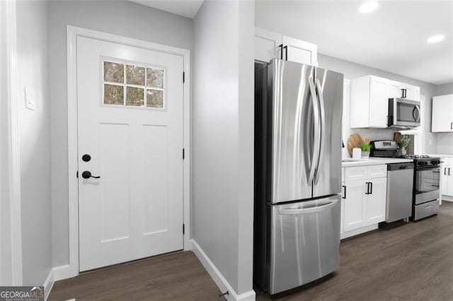 kitchen featuring baseboards, white cabinets, appliances with stainless steel finishes, dark wood-type flooring, and light countertops