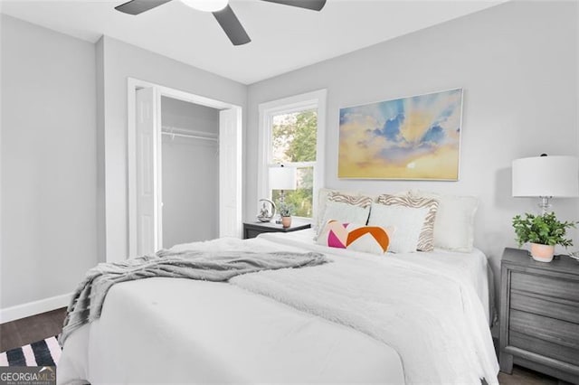 bedroom featuring dark wood-style floors, a closet, baseboards, and a ceiling fan