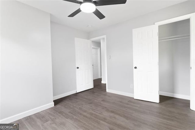 unfurnished bedroom featuring dark wood-style floors, a ceiling fan, baseboards, and a closet